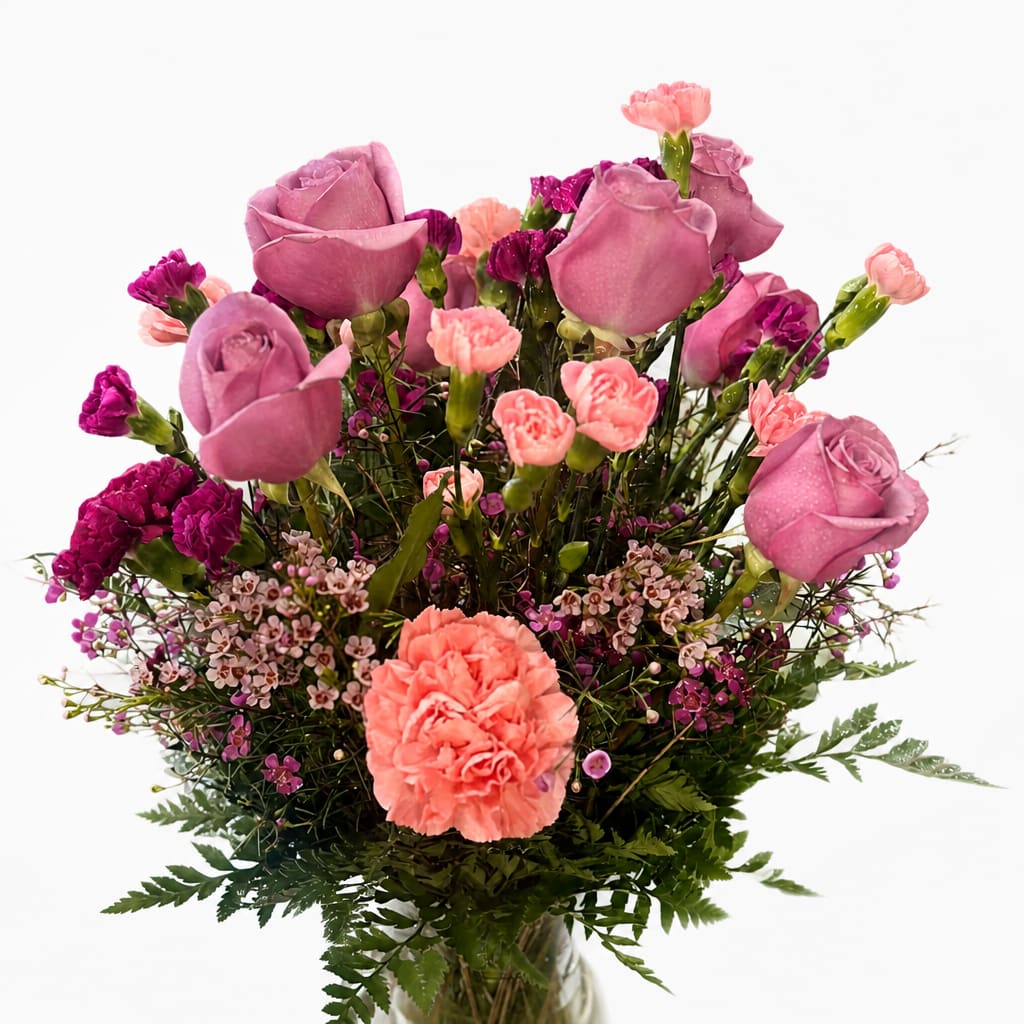 Pink roses and carnations arranged in a clear glass vase