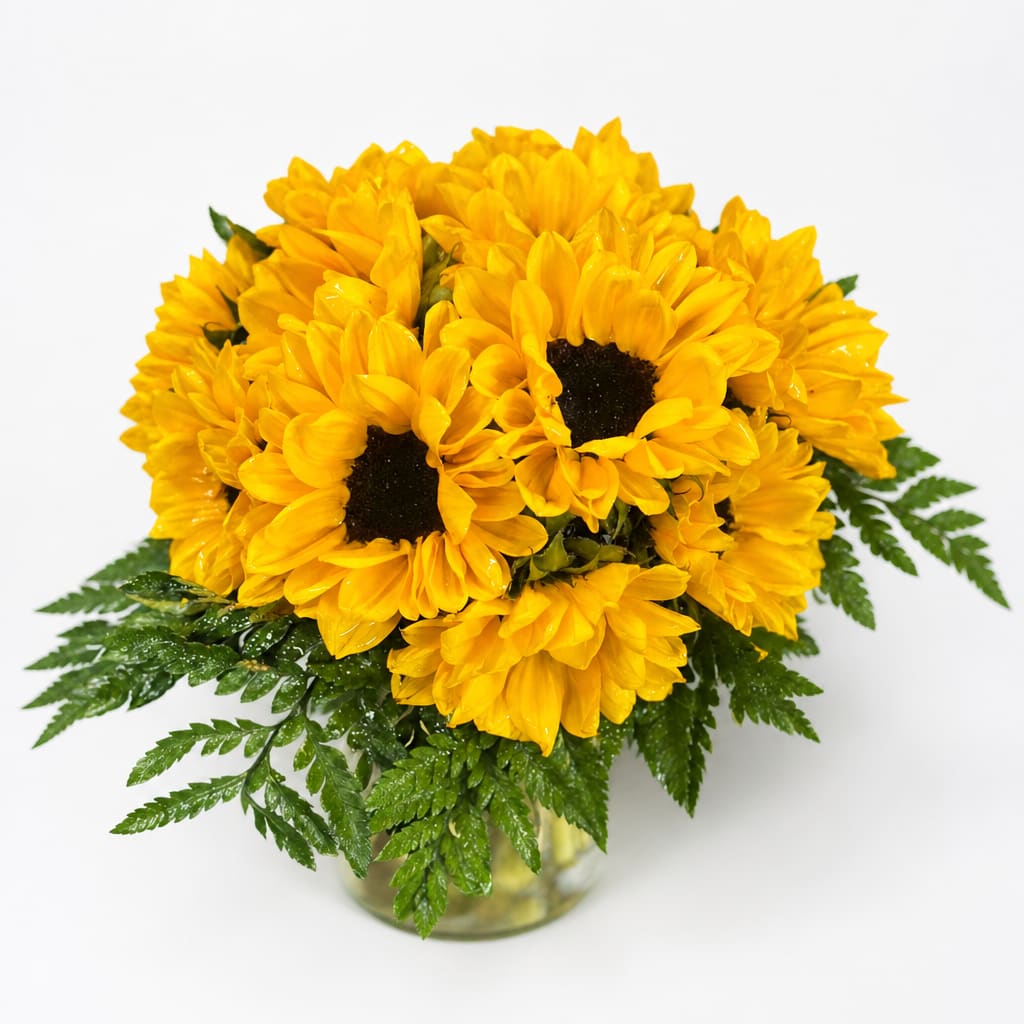 Yellow sunflowers arranged in a clear glass vase