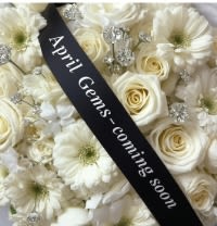 White roses and daisies with a black mourning ribbon