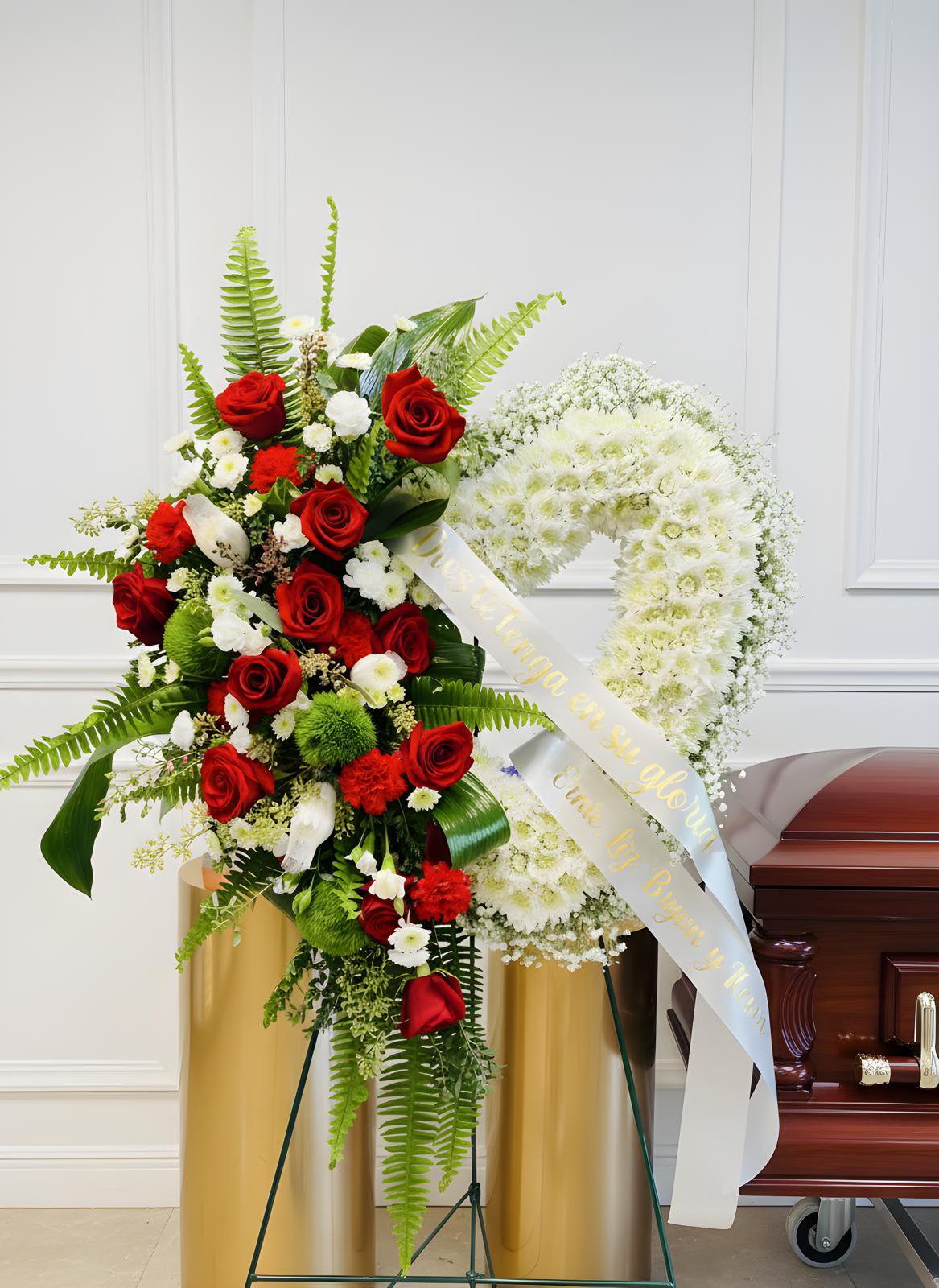 Standing funeral spray with red roses and white flowers beside a casket