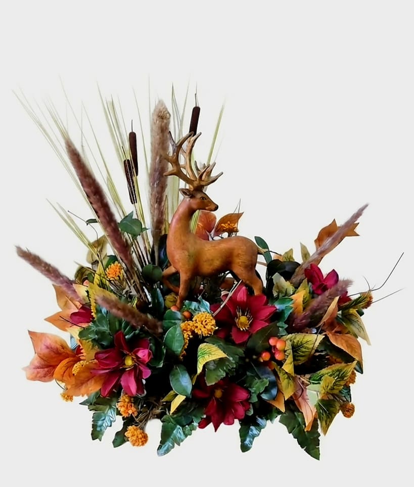Autumn floral arrangement with a deer figurine and tall grasses