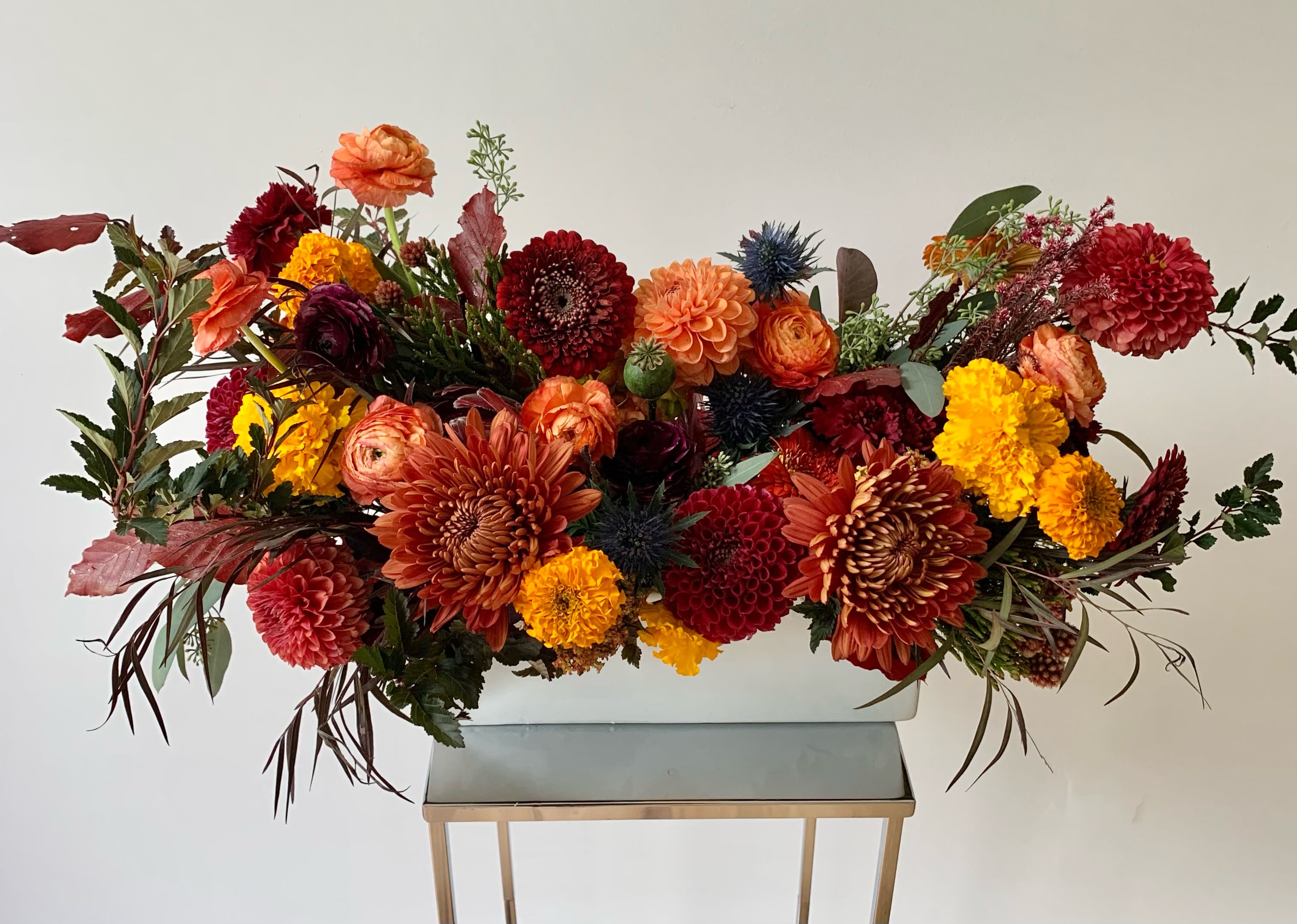 Large autumn flower arrangement in a white rectangular container