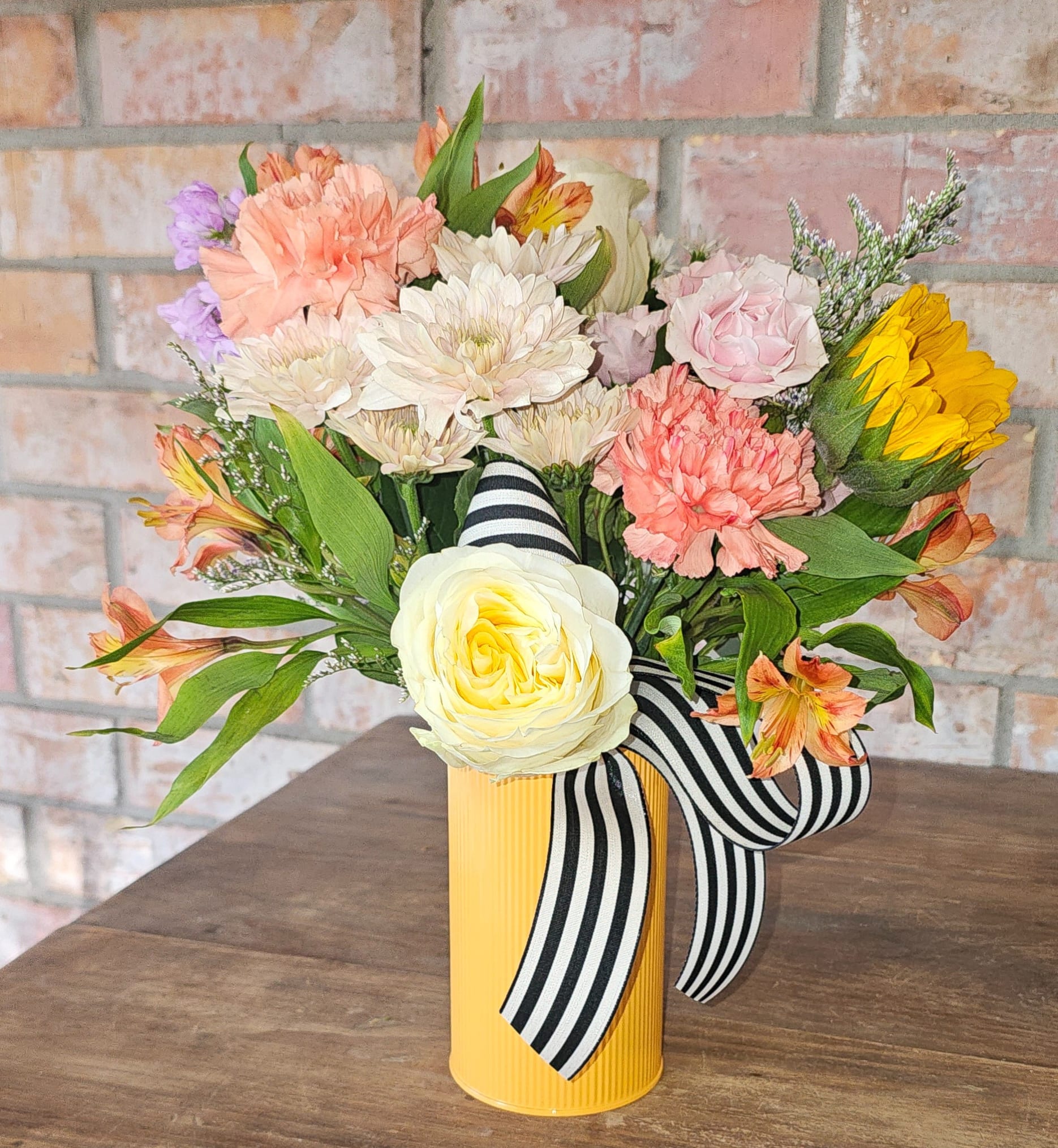 Cutie Garden Pails - Playful, charming, and effortlessly giftable.  The Cutie Garden Pail is a designer’s choice arrangement featuring a fresh mix of seasonal blooms styled in a petite, garden-inspired container. Designed to feel light, cheerful, and full of personality, this piece brings a soft pop of color to any space.  Each arrangement is thoughtfully curated using a rotating selection of florals — which may include roses, spray roses, lilies, sunflowers, stock, chrysanthemums, alstroemeria, and seasonal greenery — ensuring every design feels unique and in season.  Perfect for everyday gifting, this arrangement is a go-to for birthdays, thank you moments, get well wishes, or simply brightening someone’s day.  Compact in size but full of detail, the Cutie Garden Pail is an easy, thoughtful way to send something beautiful without overthinking the moment.