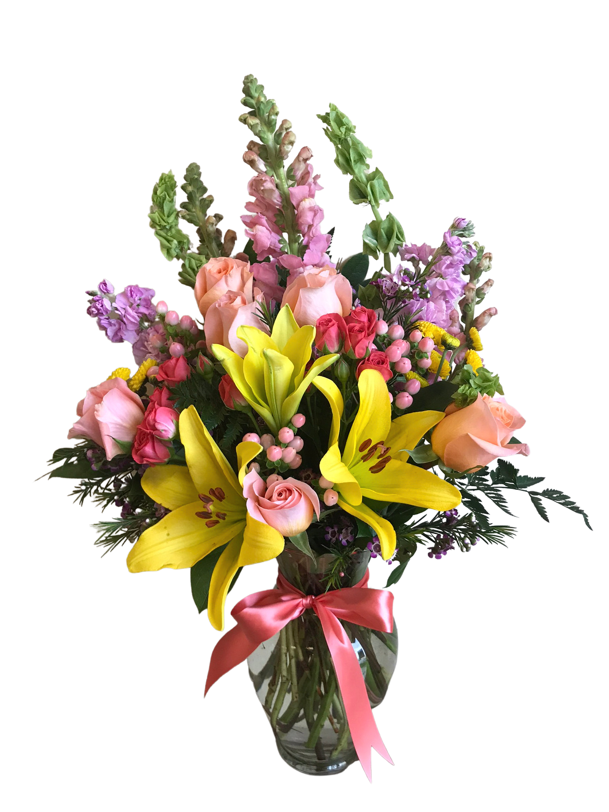 Mixed bouquet of yellow lilies, pink roses, and purple flowers in a glass vase