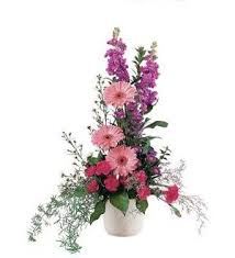 Tall pink and purple floral arrangement in a white vase