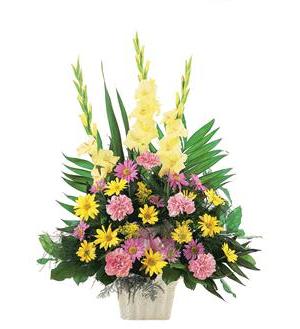 Pink and yellow mixed flower arrangement in a white container