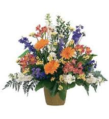 Mixed bouquet of orange, purple, white, and pink flowers in a basket