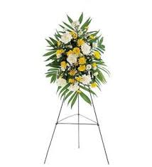 Standing floral spray with white and yellow flowers on an easel