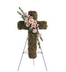 Floral cross on an easel with pink roses and greenery