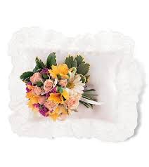 Mixed bouquet of pink roses and yellow daisies on a white pillow