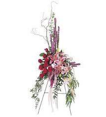 Tall floral standing spray with red and pink flowers on an easel