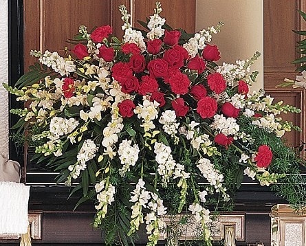 Large funeral spray of red roses and white flowers