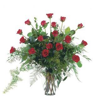 Tall bouquet of red roses in a clear glass vase