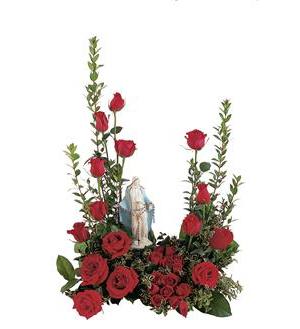Red roses arranged around a small religious statue