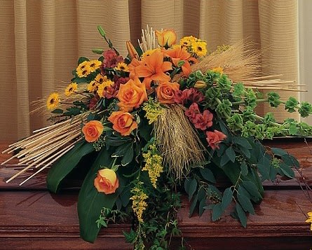 Large orange and yellow floral arrangement with roses and lilies