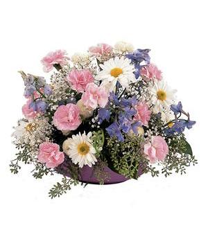 Mixed bouquet of pink, white, and purple flowers in a purple container
