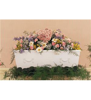 Large pastel floral arrangement in a white casket