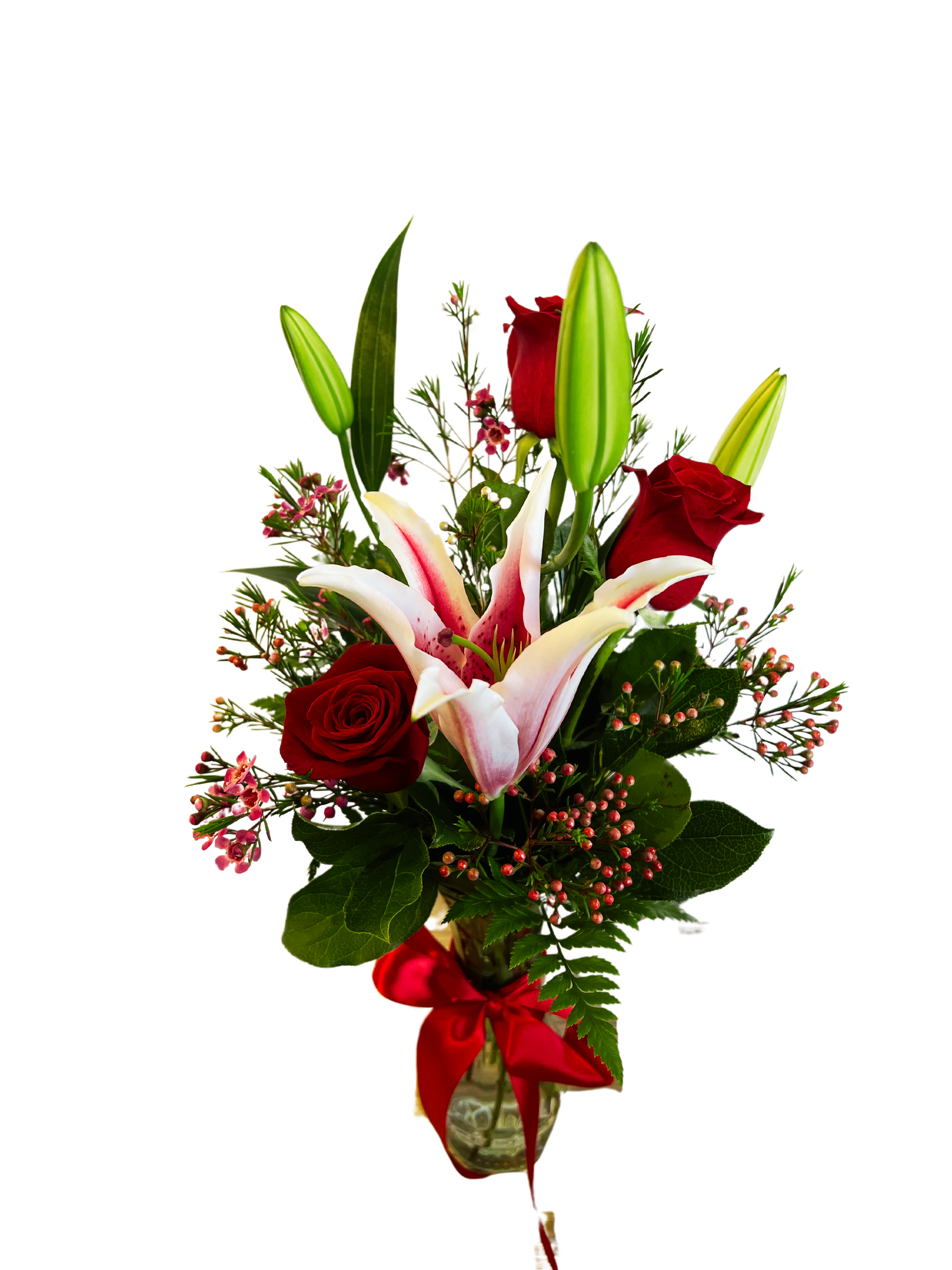 Red roses and pink lilies in a glass vase with a red ribbon