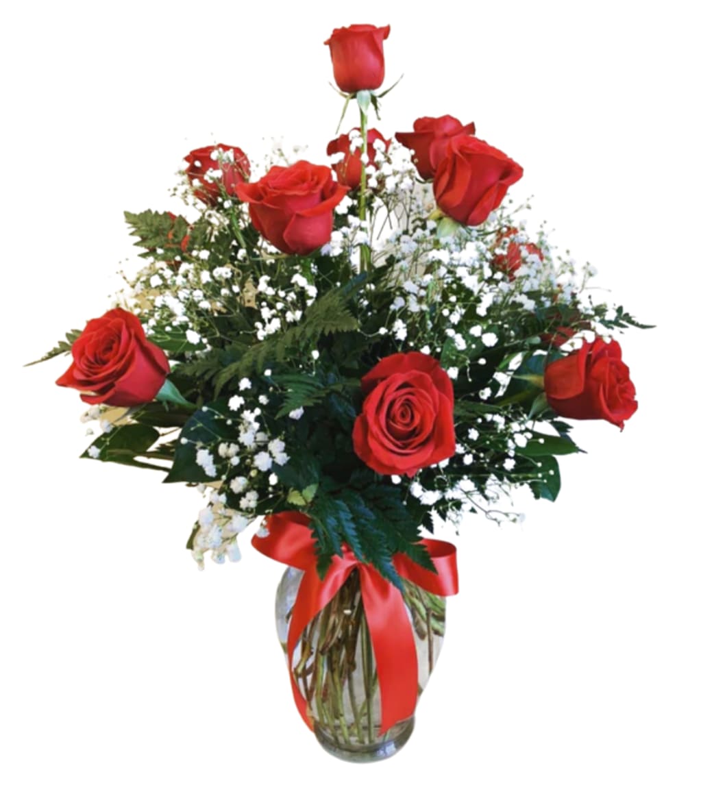 Red roses arranged in a glass vase with a red ribbon