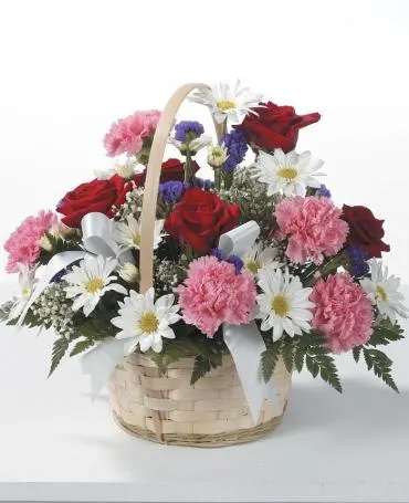 Basket arrangement with red roses, pink carnations, and white daisies