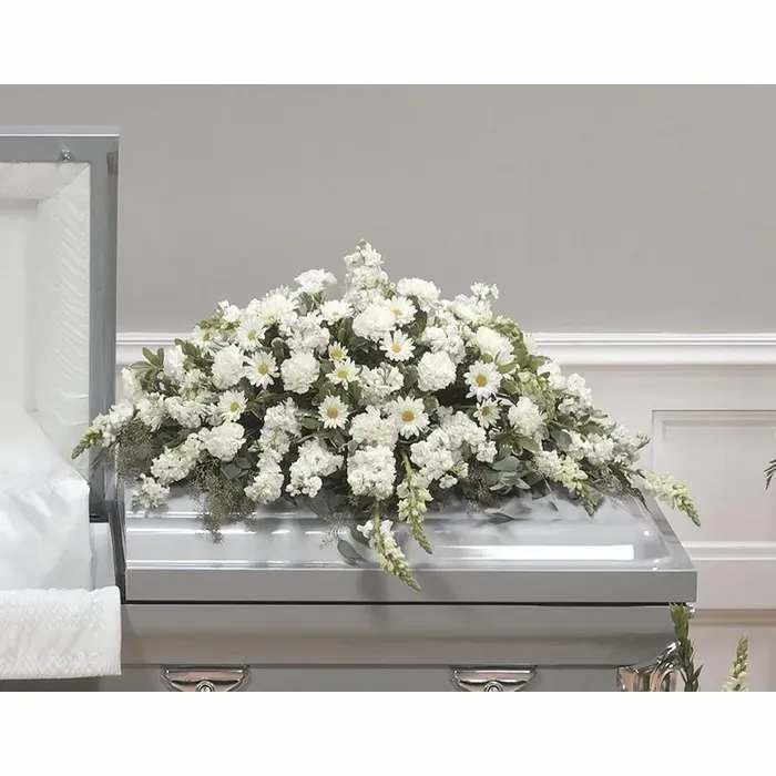 White floral casket spray with daisies and carnations