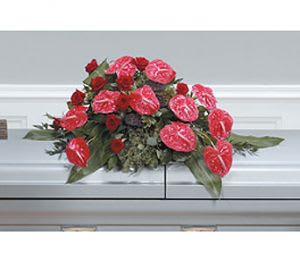 Red floral casket spray with anthuriums and roses