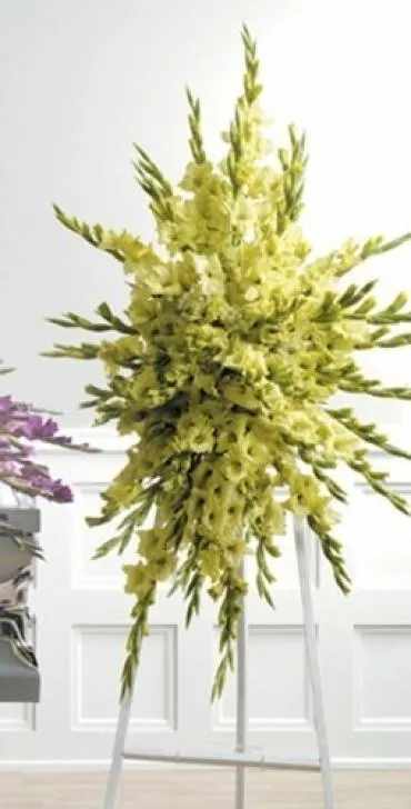 Tall yellow floral spray with long pointed blooms on a stand