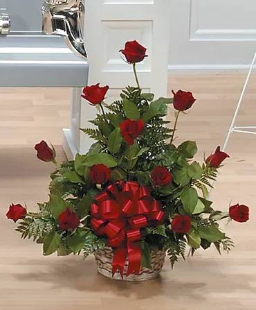 Basket arrangement of red roses with a large red bow