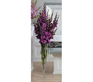Tall purple floral arrangement in a clear glass vase