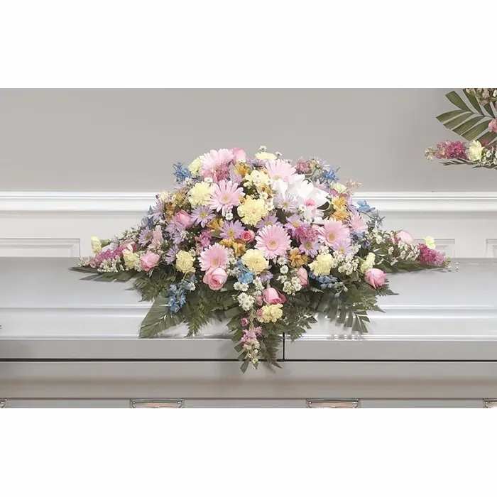 Pastel floral casket spray with pink, white, and yellow blooms