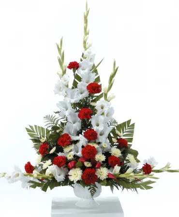 Tall red and white floral arrangement in a clear vase