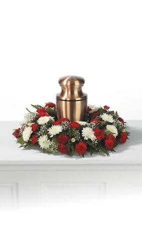 Red and white floral wreath around a bronze urn