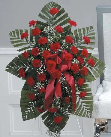 Standing floral spray with red carnations and ribbon accents