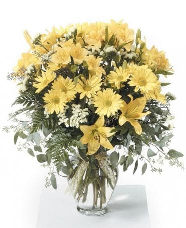 Yellow flowers arranged in a clear glass vase