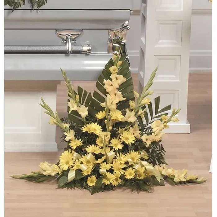 Tall yellow floral spray with palm leaves and ribbon accents