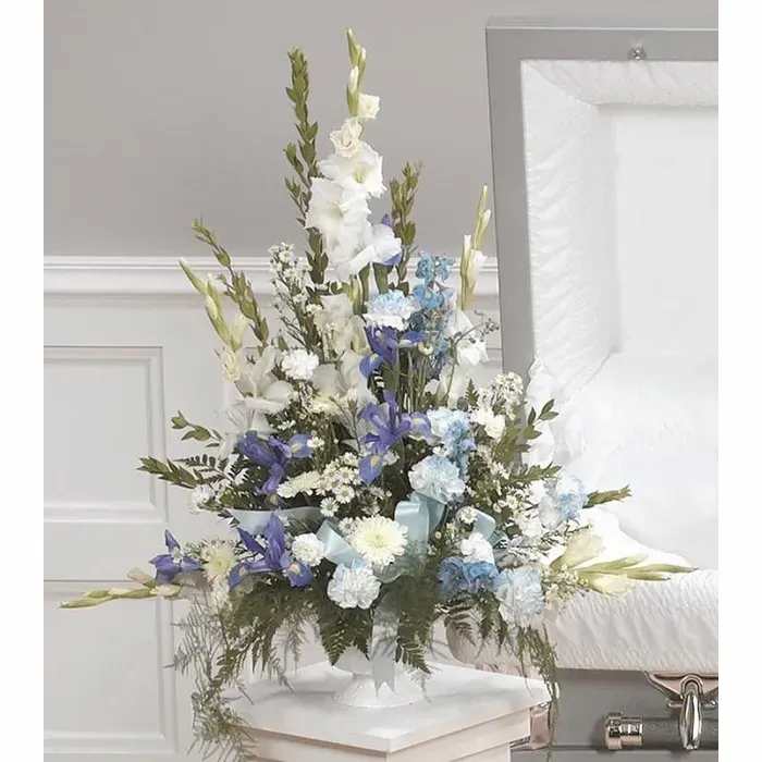 Tall white, blue, and purple floral arrangement in a white vase