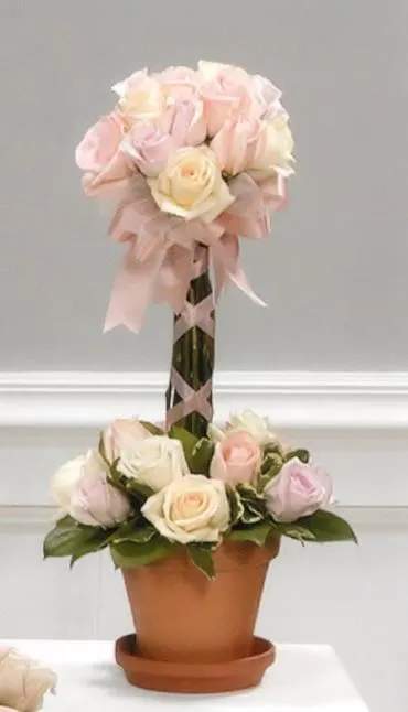 Two-tier rose arrangement in a terracotta pot with pink ribbon