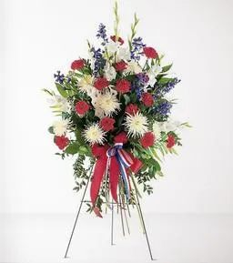 Standing floral spray with red, white, and blue flowers on an easel