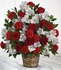 Red roses and white carnations in a woven basket