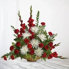Red and white floral arrangement in a woven basket