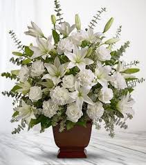 White lilies and roses arranged in a brown vase