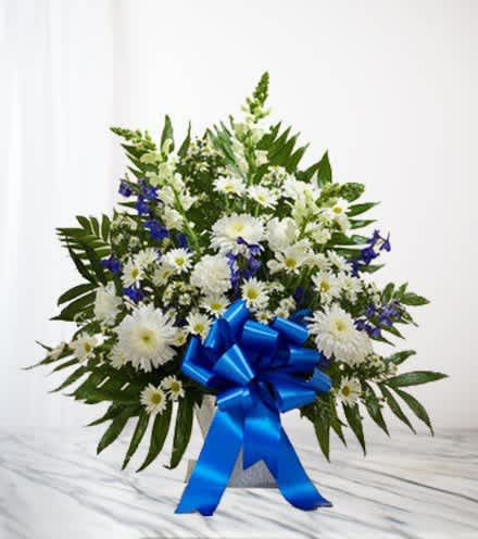 White and blue floral arrangement with a large blue ribbon
