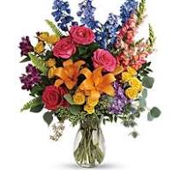 Colorful mixed bouquet with roses, lilies, and snapdragons in a glass vase