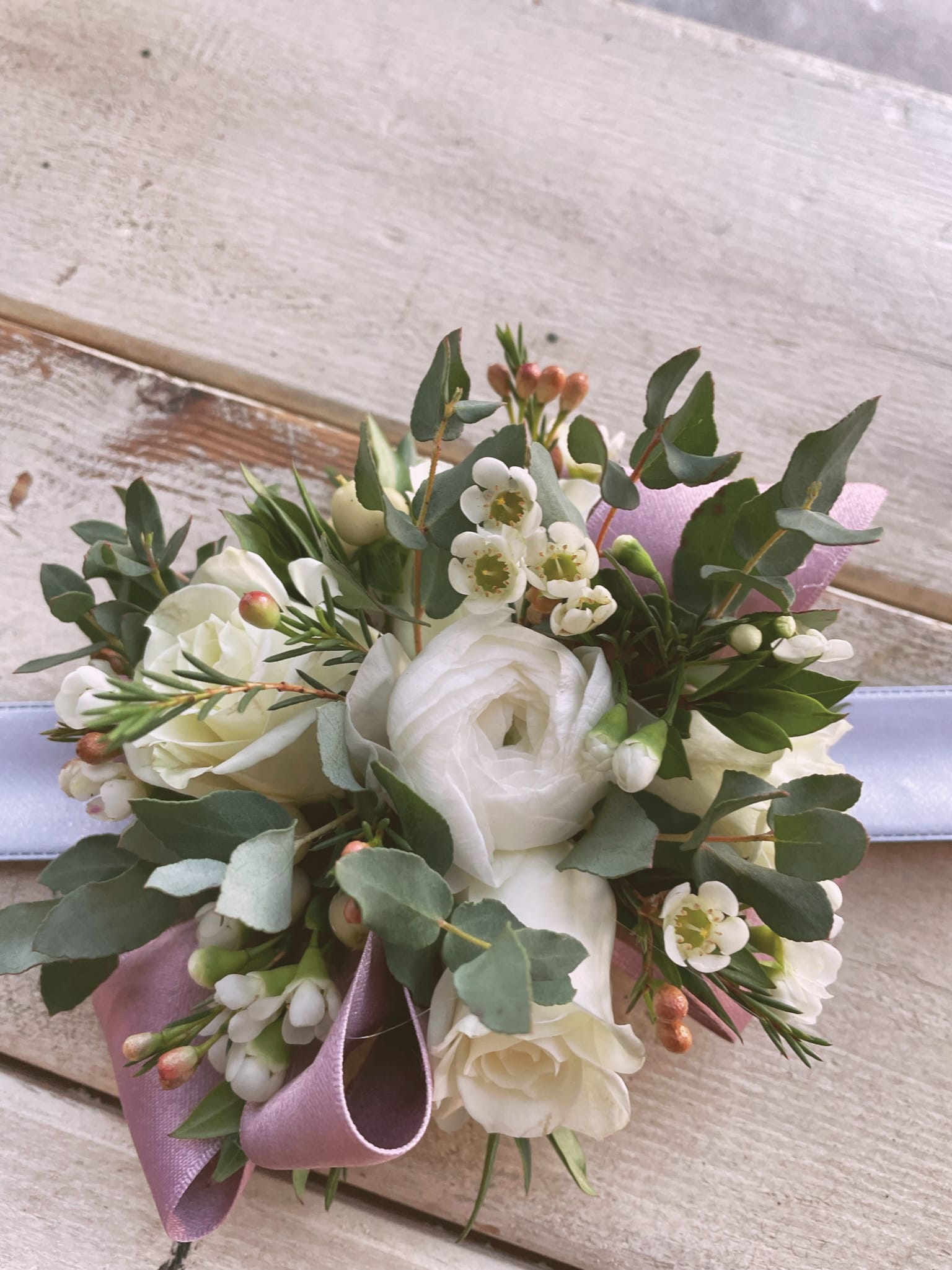 White rose bouquet with small white blossoms and a lavender ribbon