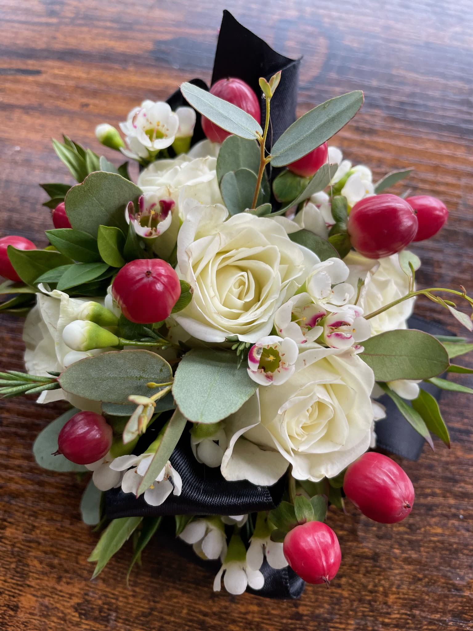 White rose bouquet with pink berries and small white blossoms