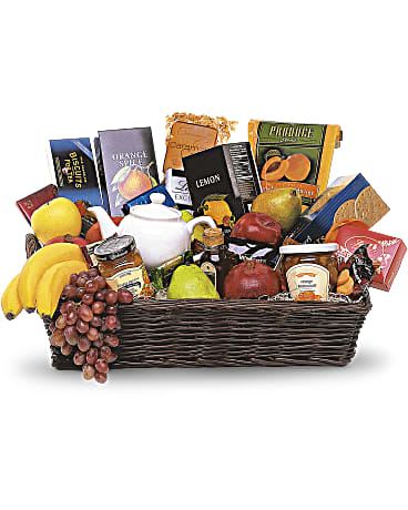 Gift basket with fruit, snacks, and a white teapot