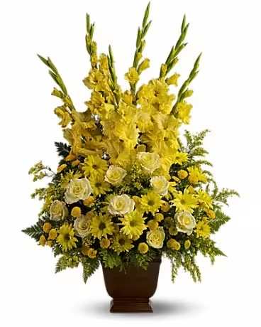 Tall yellow floral arrangement in a brown urn vase