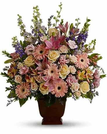 Large mixed flower arrangement in a brown urn vase