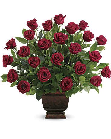 Red roses arranged in a dark urn vase