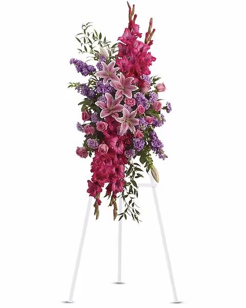 Tall floral spray with pink lilies, roses, and purple flowers on a stand